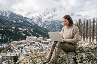 Femme assise sur un rocher avec vue sur Briançon