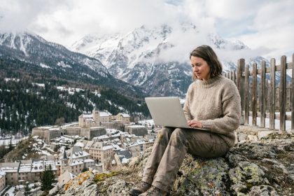 Femme assise sur un rocher avec vue sur Briançon